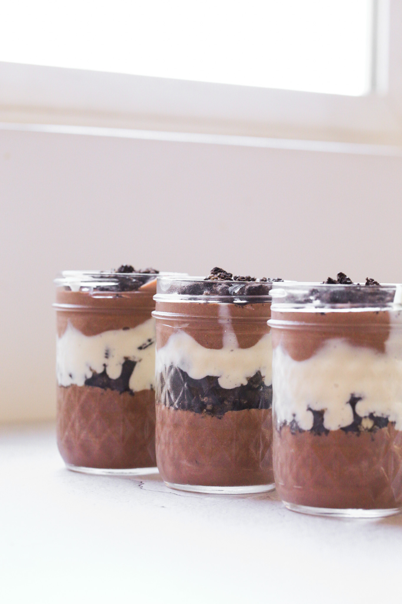 three oreo pudding parfaits by the window