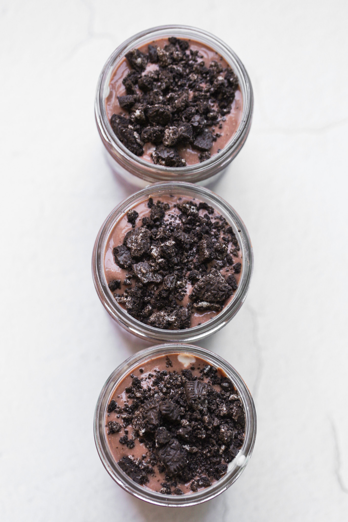 overhead shot of oreo cookies on pudding, in jars