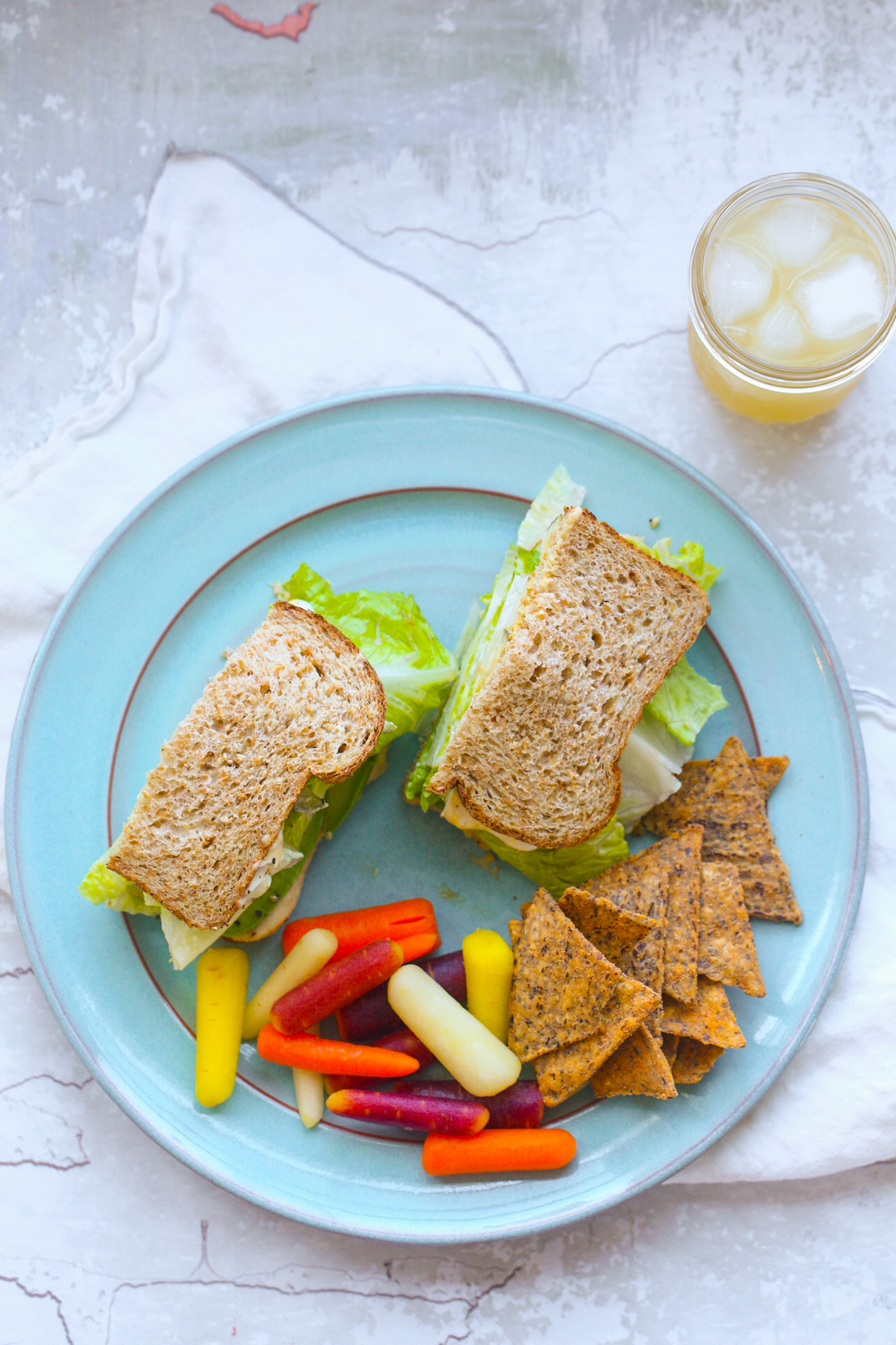 lunch plate with avocado hummus sandwich and carrots