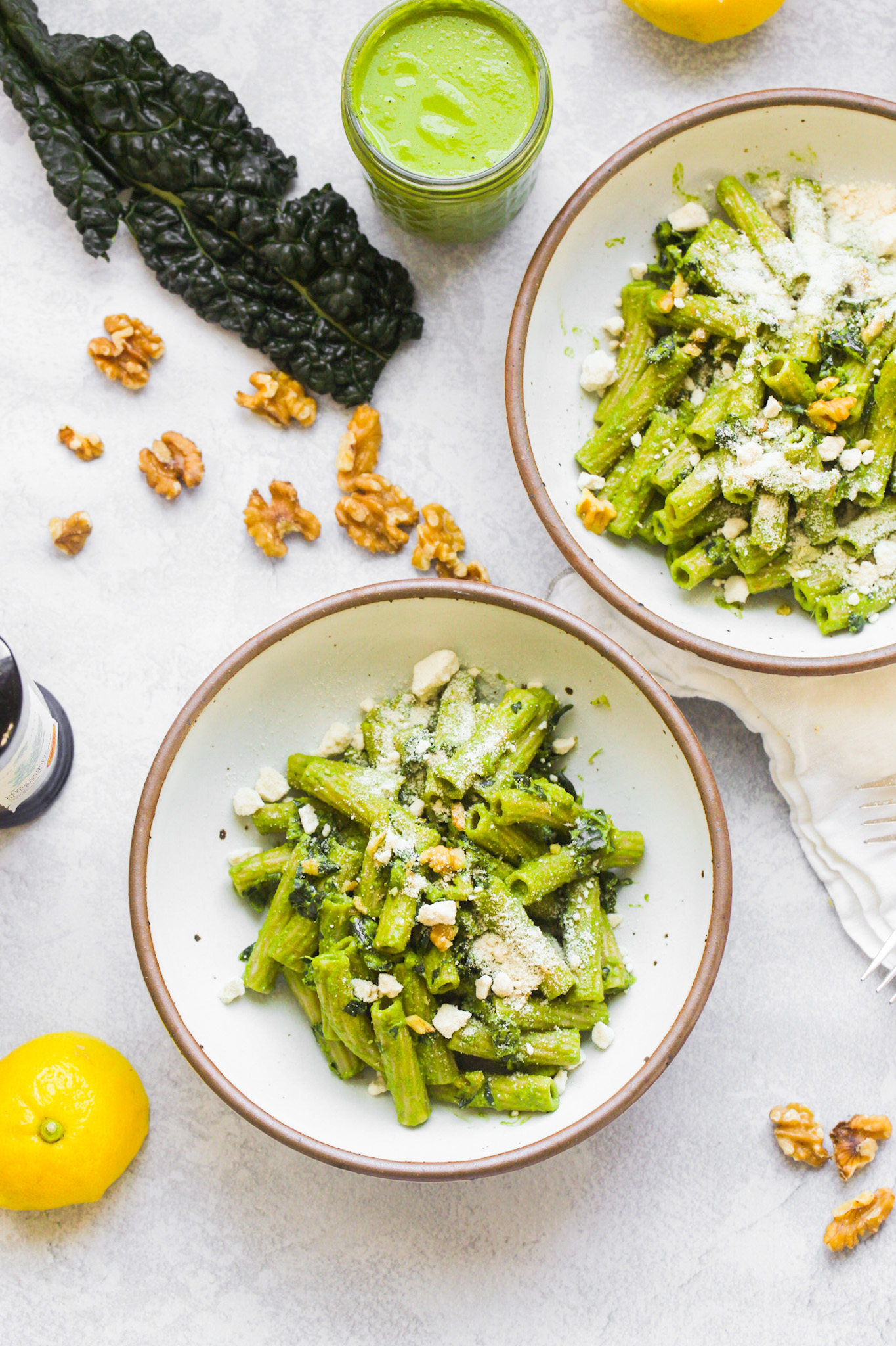 two kale pasta bowls with walnuts and cheese