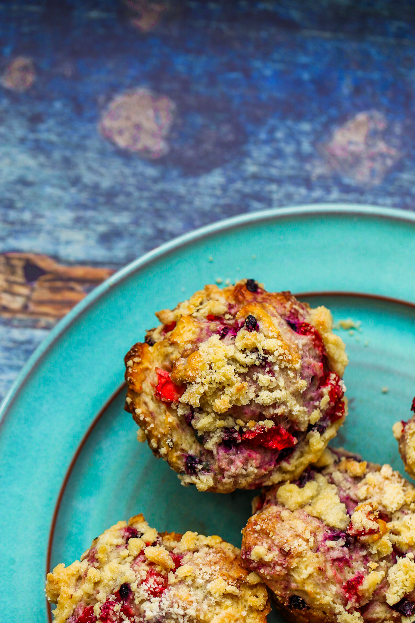 Double Berry Crumble Muffins on turquoise plate