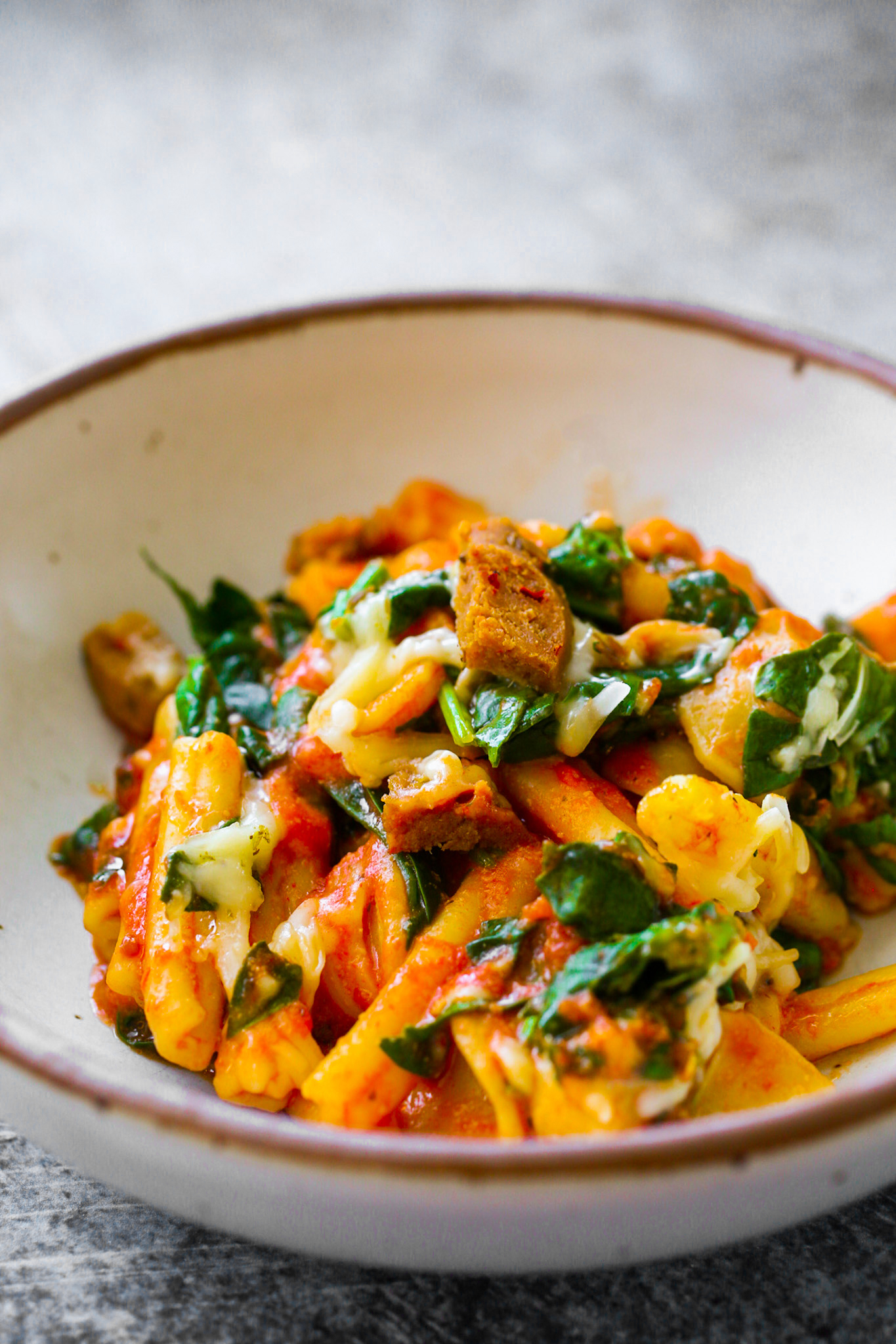 bowl of cheesy pasta with tomato sauce