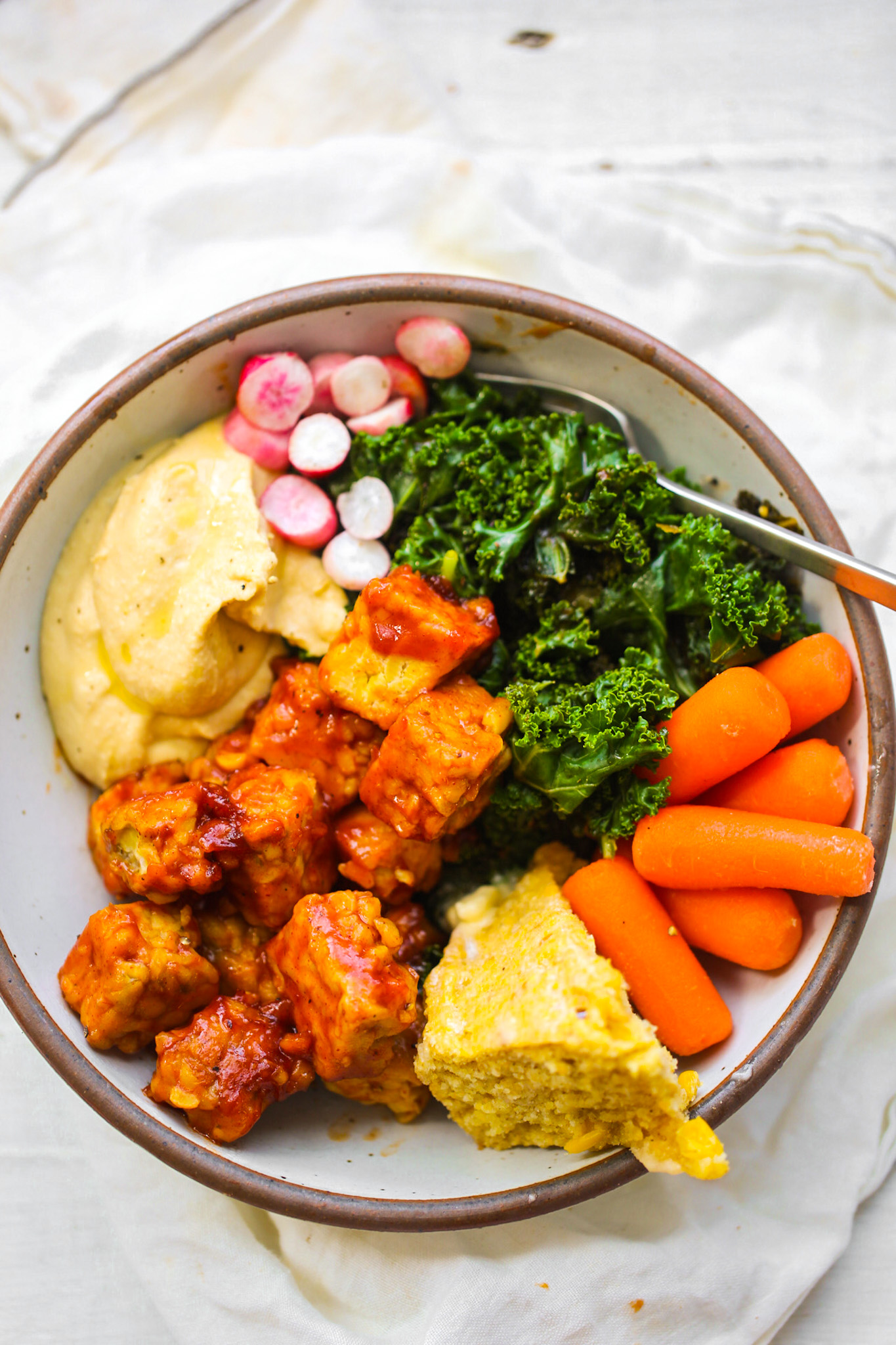 plant power southern bbq tempeh kale bowl with carrots and corn bread