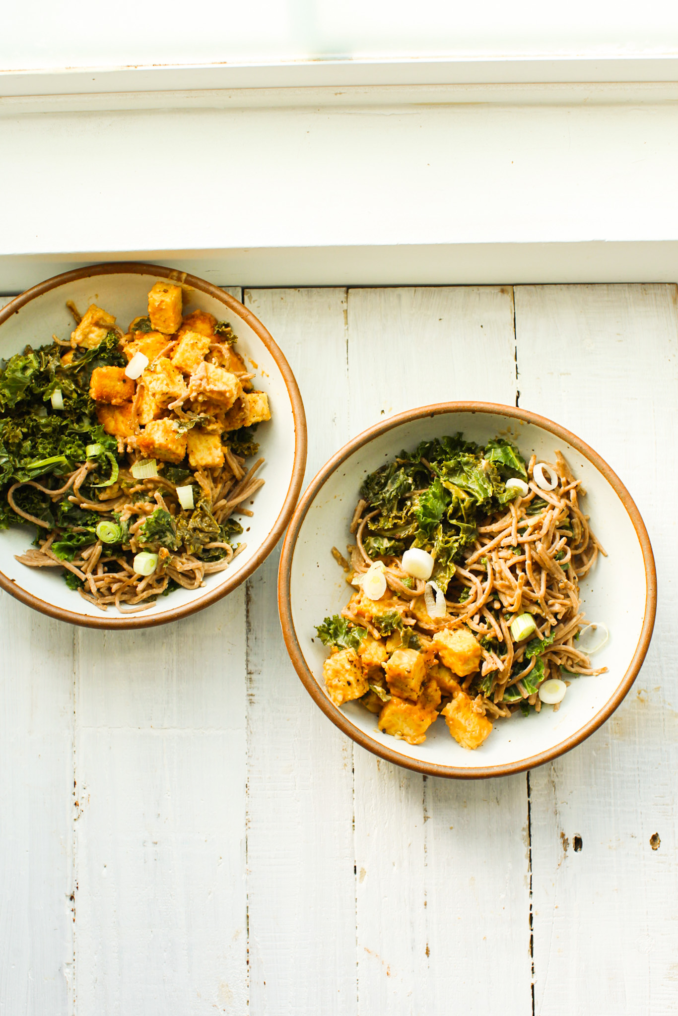 overhead of peanut noodle bowls with veggies