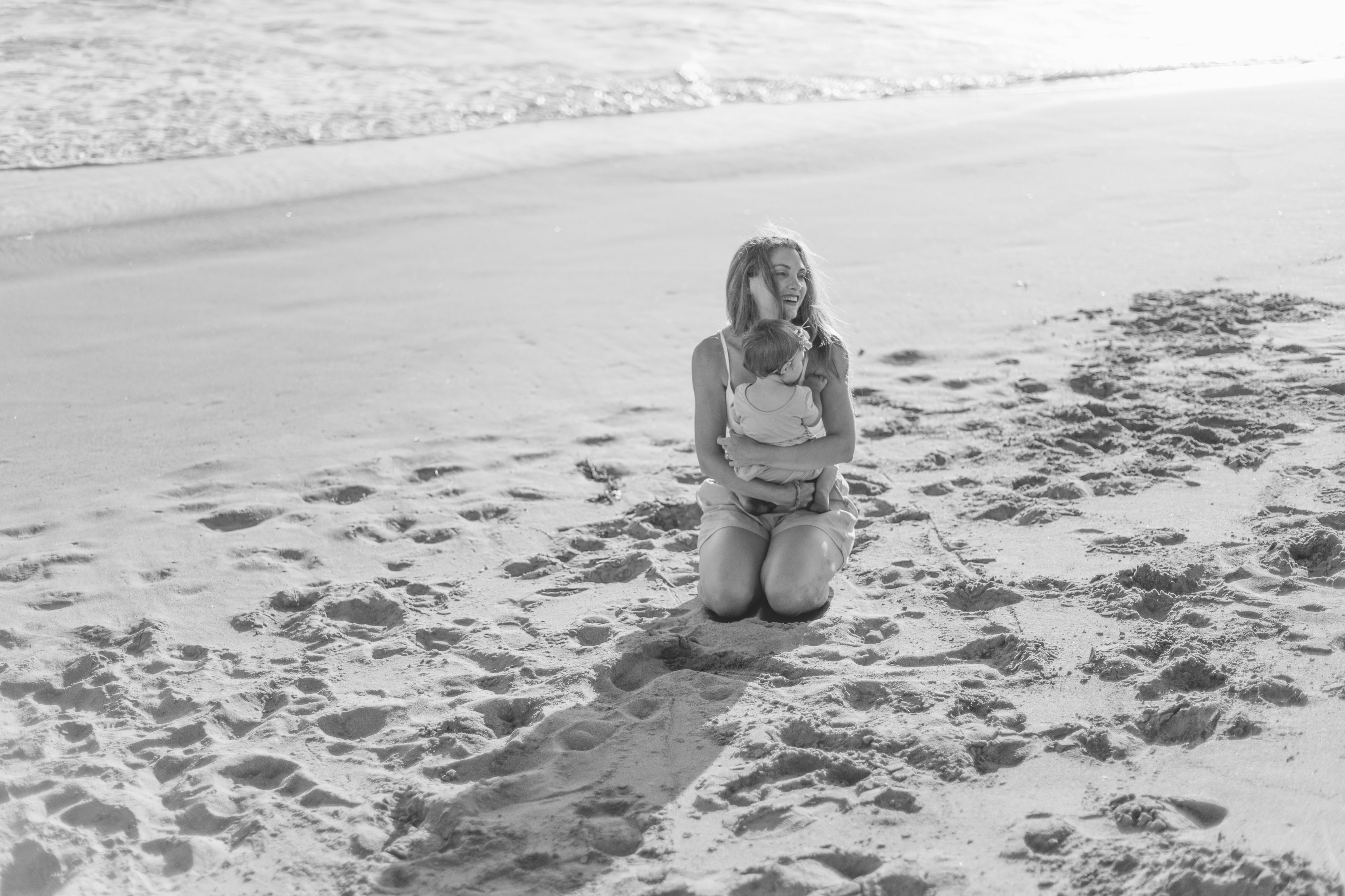 mommy hugging baby beach California